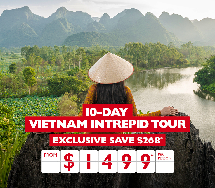 Woman looking out at lush green fields and mountains in Vietnam