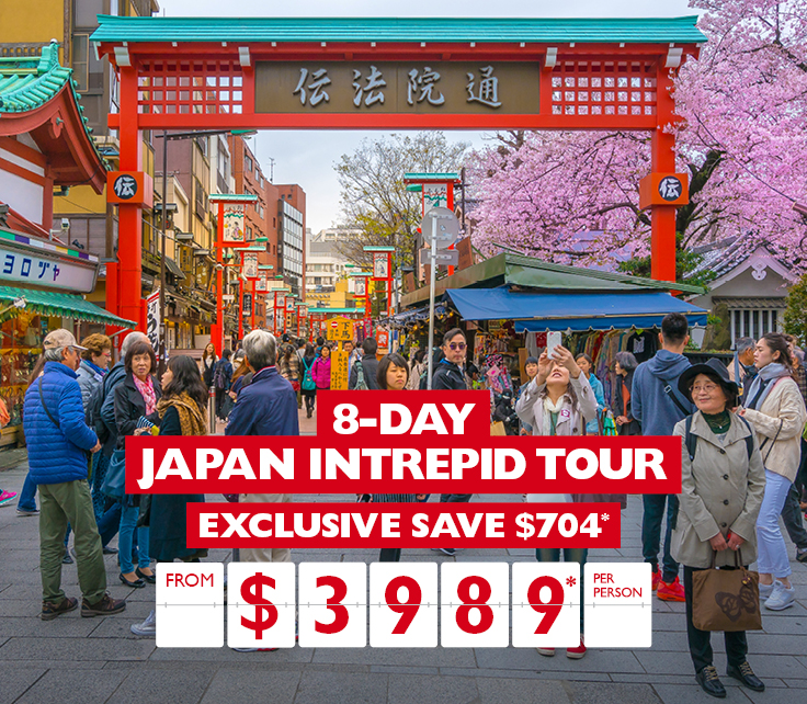 Busy market street in Japan with red Tori gates and cherry blossoms