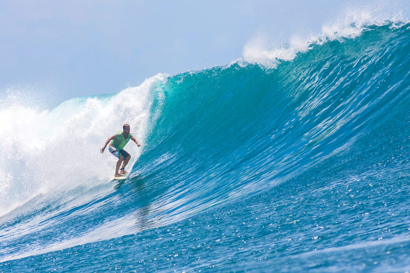 A surfer rides a wave in Lombok, Indonesia.