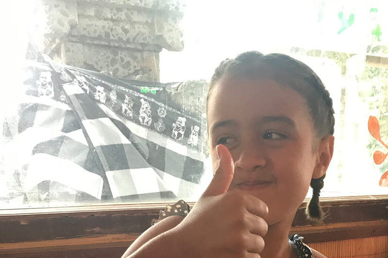 Girl in front of shrine in restaurant, Bali