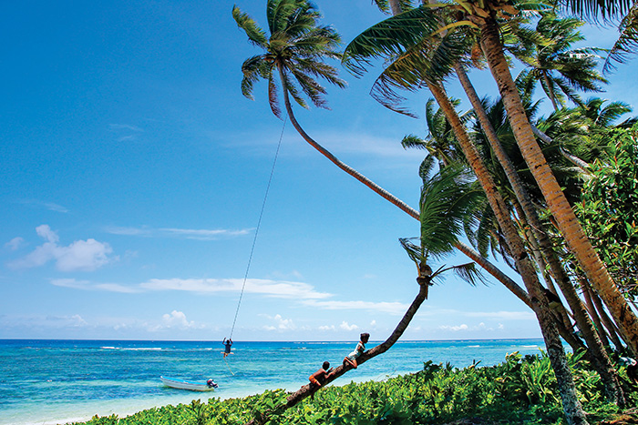 Young kids play in palm trees in Fiji - Cruise trends to try