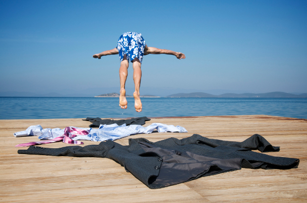 Man diving into water with work clothes on pontoon