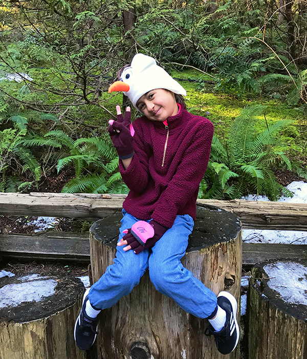 Child sitting on log at Capilano Suspension Bridge Park