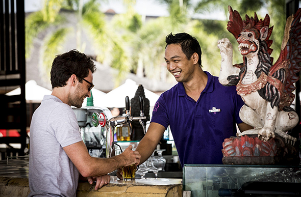 A G.O serves a guest at the bar at Club Med Bali