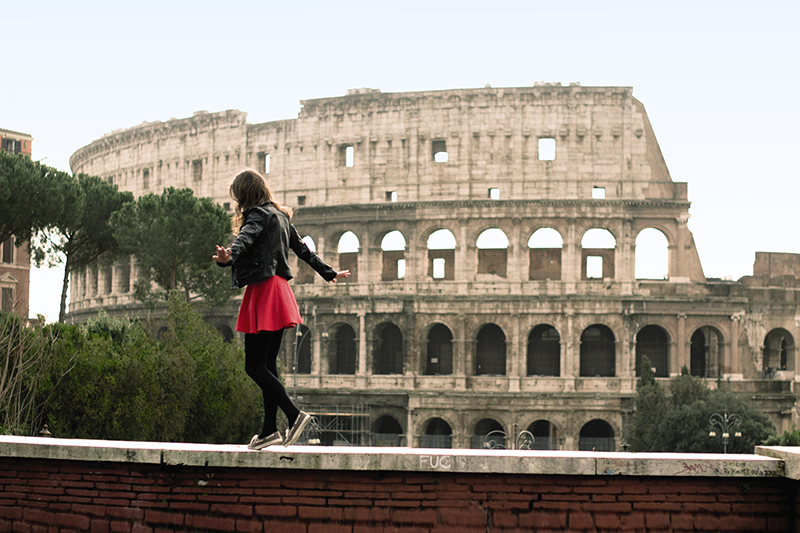 girl walking in front of the colosseum 