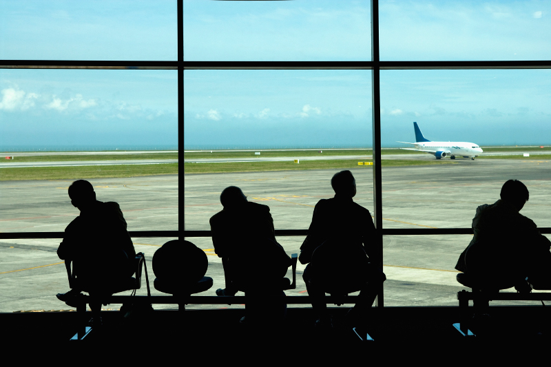 Business travellers waiting at airport.