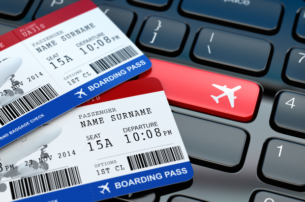 Two first class boarding passes sitting on a computer keyboard