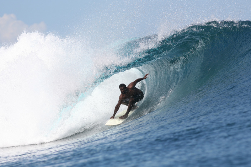 A Fijian surfer rides a wave.