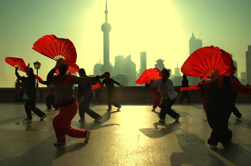 Woman do a fan dance on the Bund in Shanghai, China