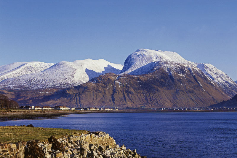 ben nevis covered in snow behind lake