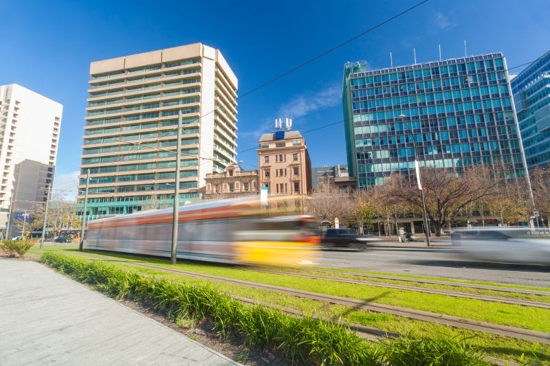 tram moving fast past modern buildings in adelaide