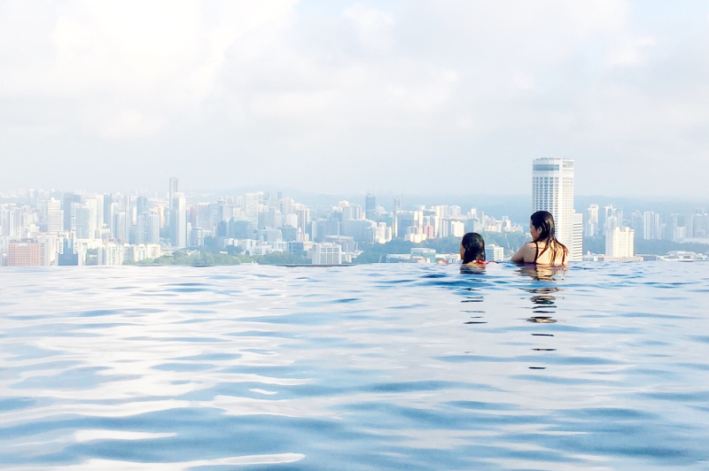 Two women in infinity pool overlooking Singapore