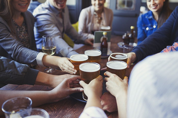 group of mates cheersing beer in british pub