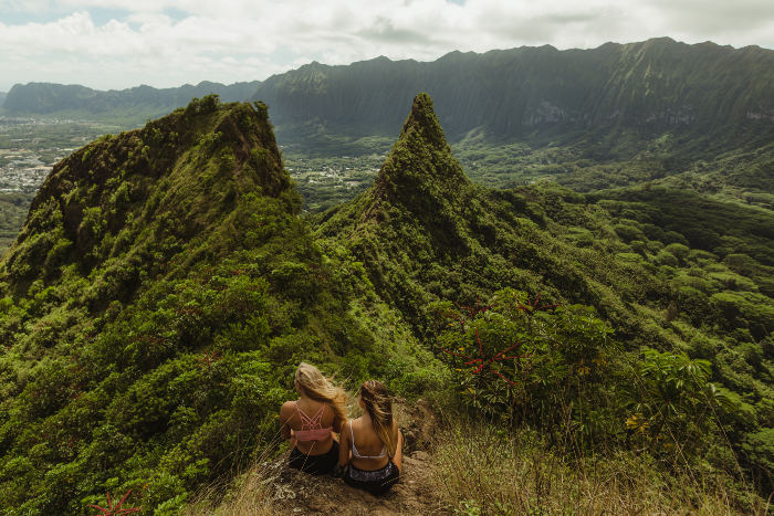 two girls sitting ontop of mountain hawaii