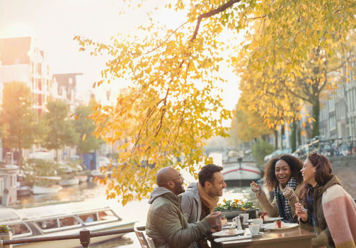 Group of people eating beside canal amsterdam