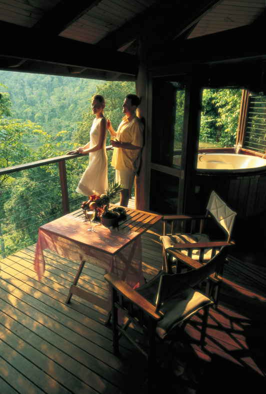 A couple enjoy the views from their balcony at Mount Quincan Crater Retreat in North Queensland.