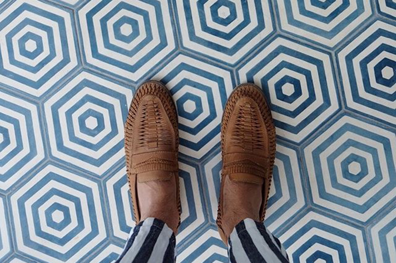 A man's feet against tiles at Halcyon House, NSW