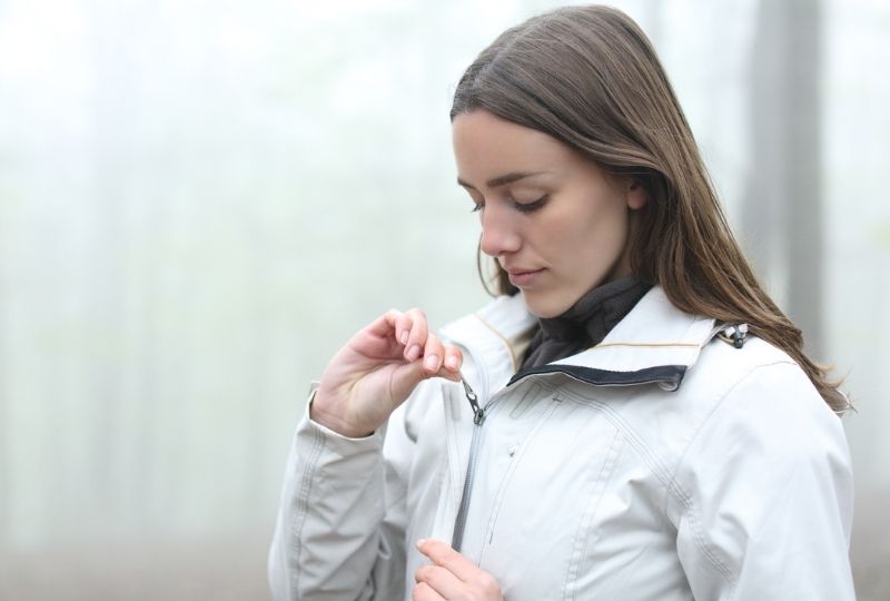 Image of a person putting on a jacket