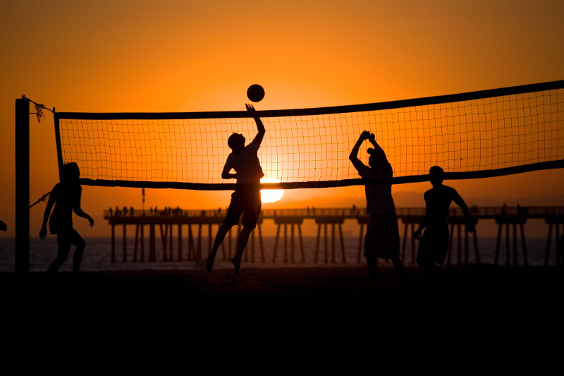 People play volleyball at sunset at LA's Hermosa Beach.