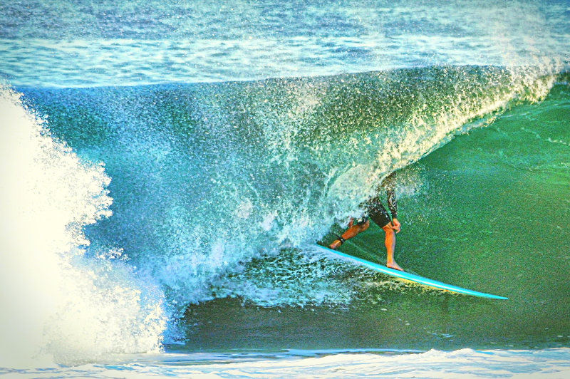 A surfer rides a wave at LA's Manhattan Beach.