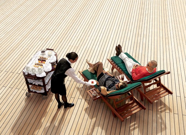 Couple being served champagne on cruise deck