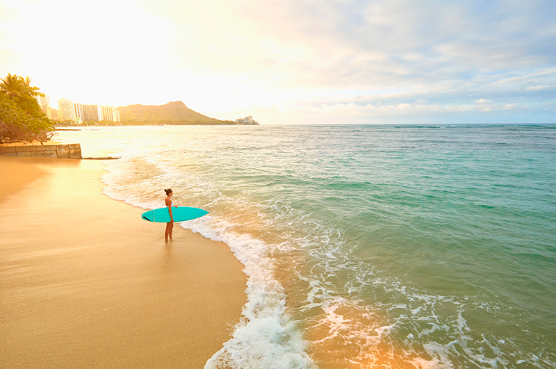 Woman with surfboard on Waikiki Beach