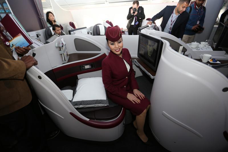 flight attendant sitting on business class seat qatar airways