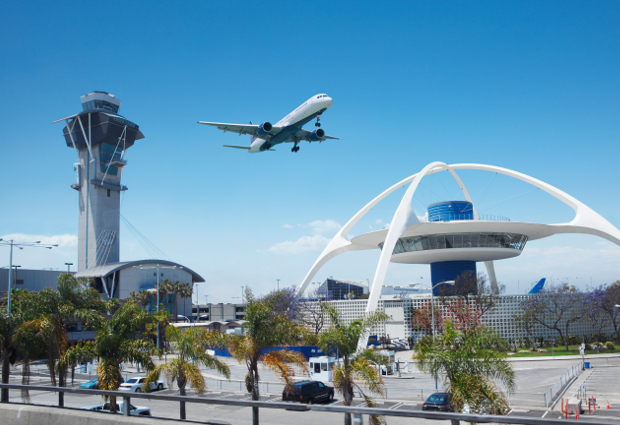 Theme building, control tower and plane taking off over LAX