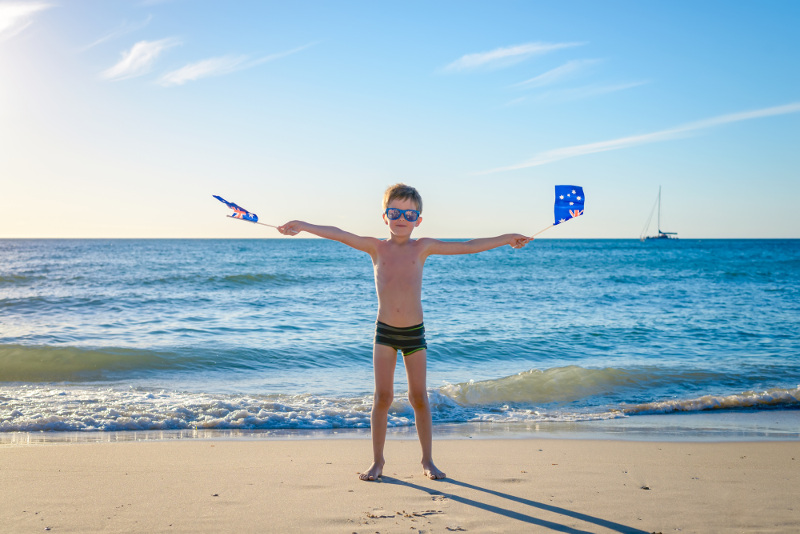 boy on beach with australia day flags
