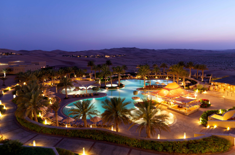 luxury hotel in desert pool at sunset