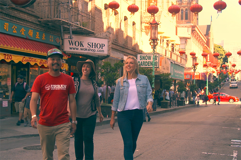 A man and two women walk through San Francisco's Chinatown.