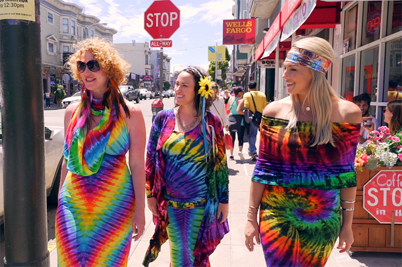 Three women in 1960s clothes walk along Haight in San Francisco.