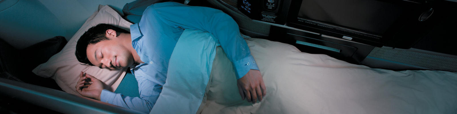 A man sleeping in his business class seat on Cathay Pacific