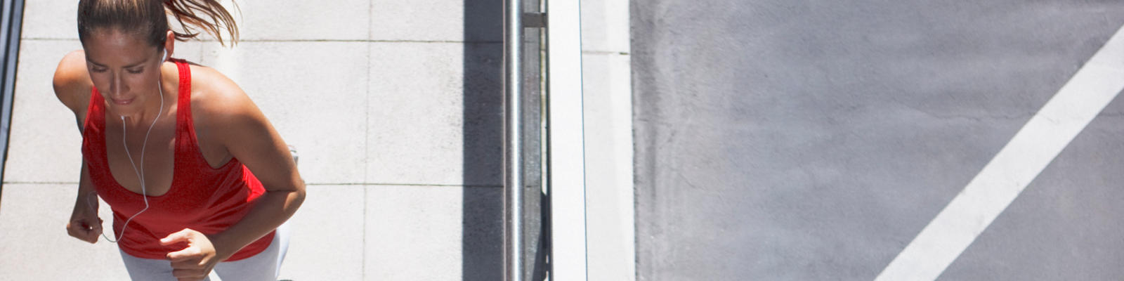 An overhead view of a woman running on a sidewalk