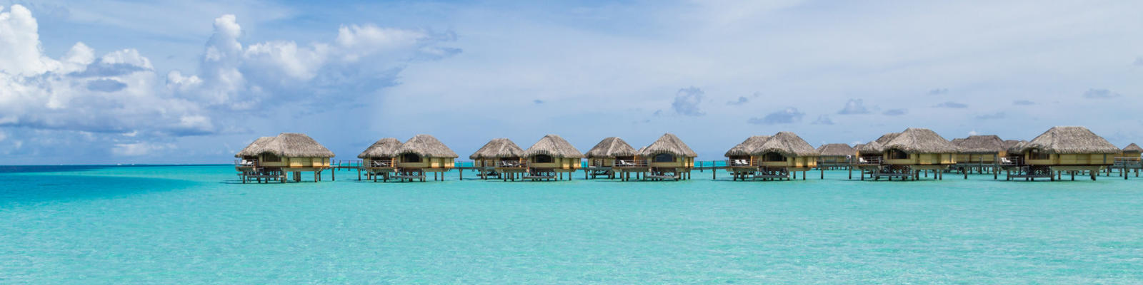 A distant shot of luxury overwater bungalows over the blue waters of Bora Bora