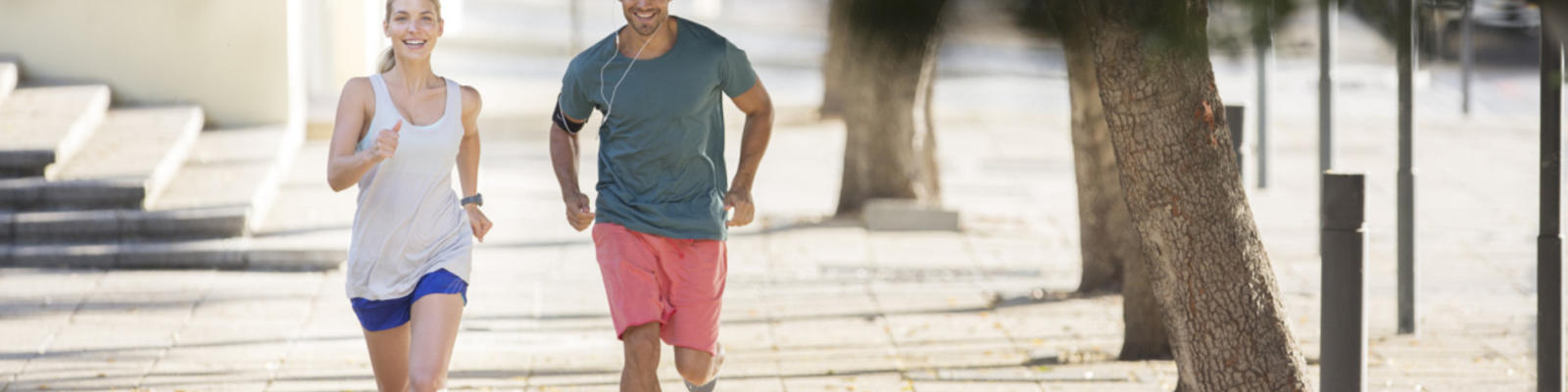 A man and a woman in jogging gear running down the street together