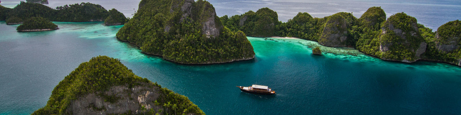 sailing boat in papua new guinea waters with islands