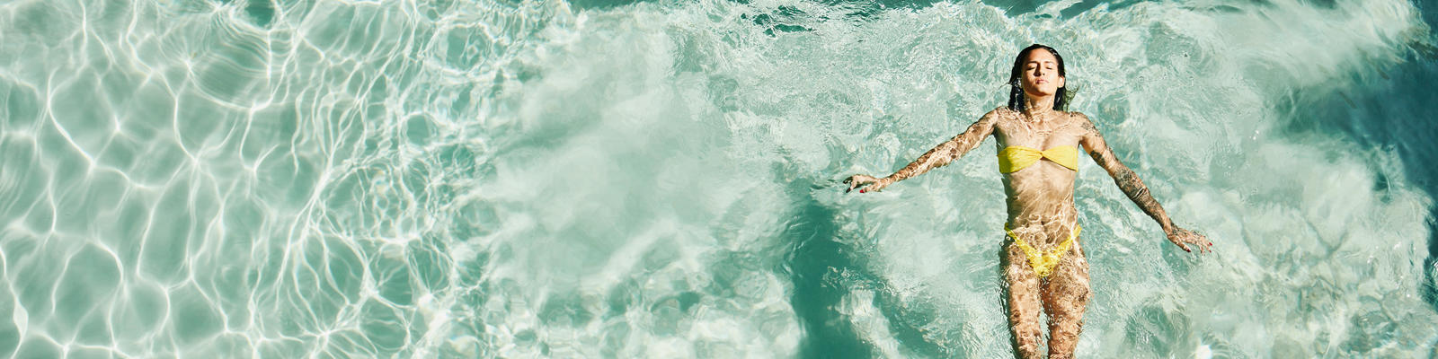 how to avoid getting sick while travelling - woman floats in a pool on holiday