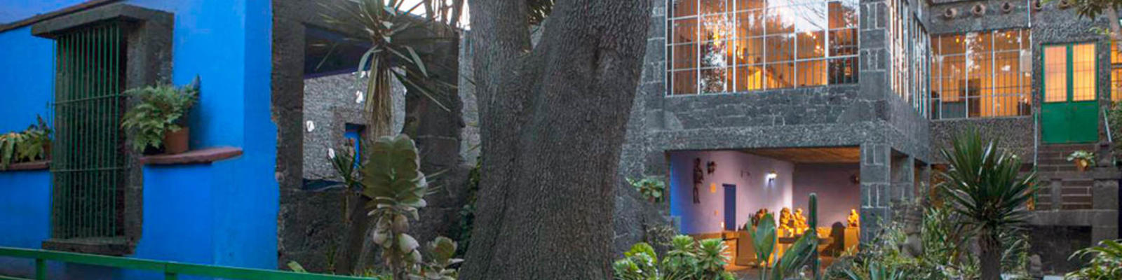 The blue wall and lush gardens of the Blue House Frida Kahlo Museum in Mexico City.