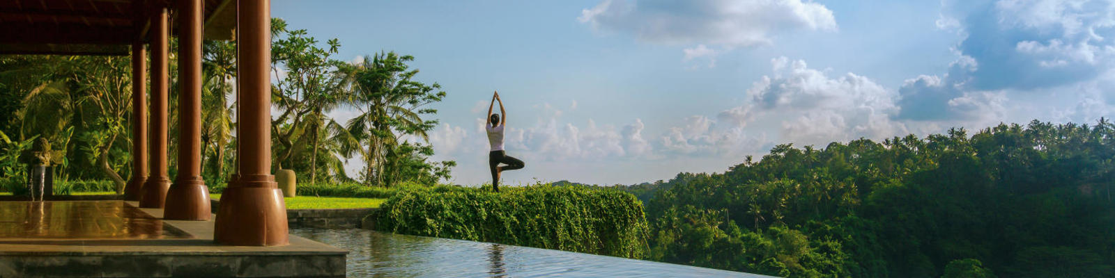 A woman performs yoga by a pool at Mandapa Ritz Carlton Ubud in Bali.
