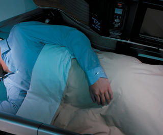 A man sleeping in his business class seat on Cathay Pacific