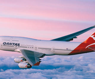 Qantas airplane flying over the purple and blue horizon