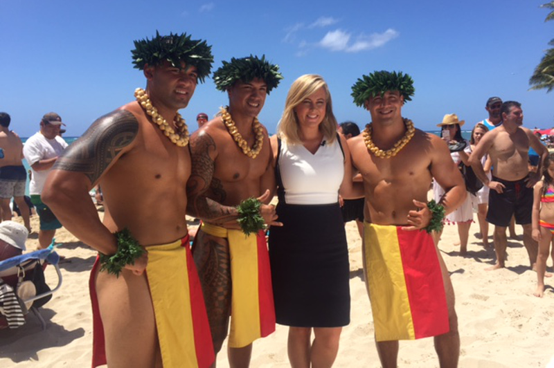 Samantha Armytage with Hawaiian men in traditional costume on the beach at Waikiki.