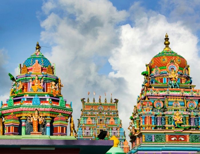 colourful Hindu temple with blue sky and white and grey clouds in background