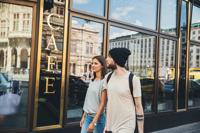 Couple pass a coffee house in Vienna