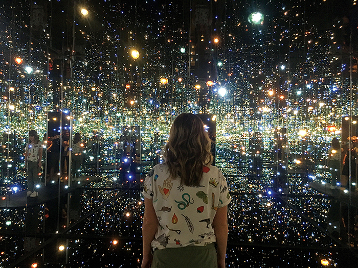 woman looking at Yayoi Kusama's Infinity Mirror